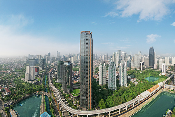 Aerial view of Jakarta skyline with tall buildings and highways.